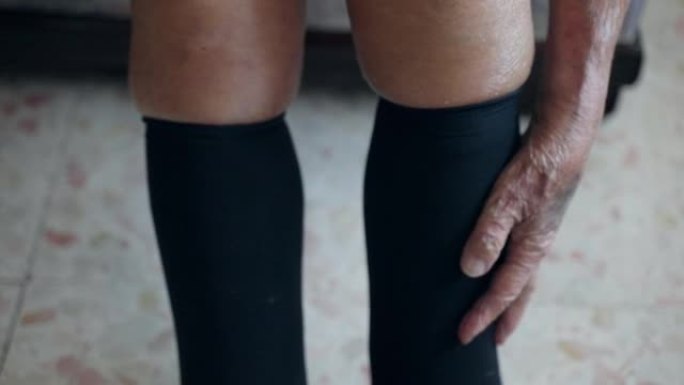 老年人腿的慢性血液循环不良，养老金领取者用手按摩冷冻腿，老祖父的贫血综合症。患有贫血症的养老金领取者