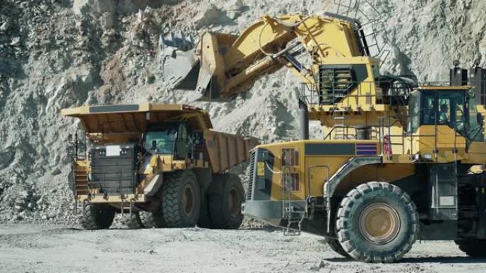 工业自卸车卡车和轮式装载机推土机在露天矿坑上工作，慢动作