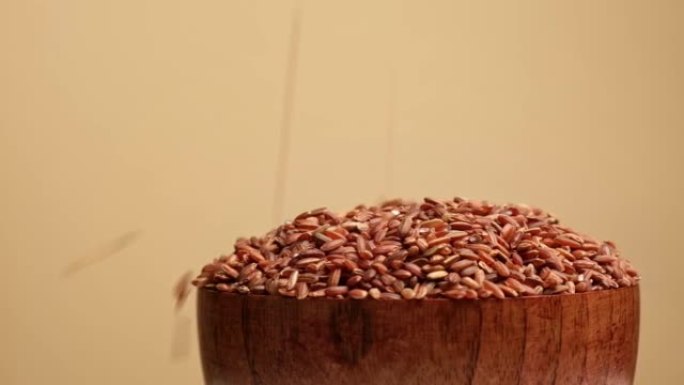 木碗干红米。长糙米旋转。特写。谷物掉落倒了一堆。世界危机，出口，进口。收获问题，制裁。价格上涨和粮食