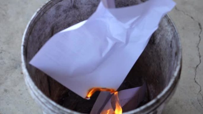 特写粉碎文件，把文件烧进垃圾桶。