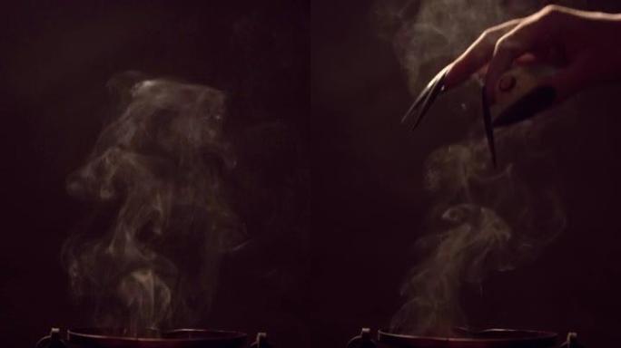 女巫的手把她的眼睛放在吸烟的大锅里。垂直视频。
