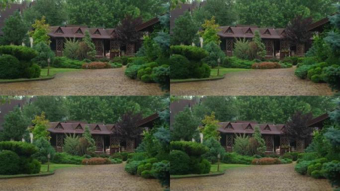 在绿色的花园中可以看到带有凉亭的木屋。维护良好的美丽花园，在雨中美化
