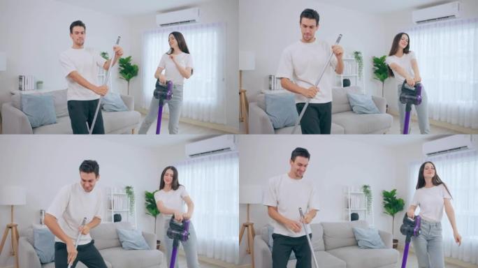 白人年轻男女一起在家打扫客厅。美丽可爱的男女夫妇跳舞，一边用吸尘器打扫脏乱的肮脏地板，做家务和家务。