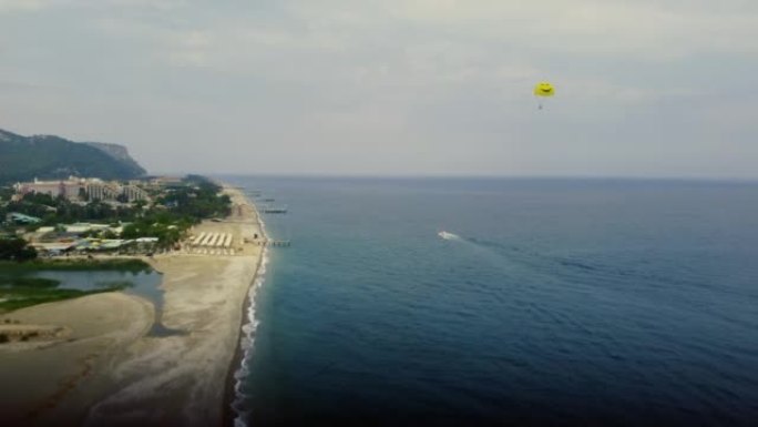 直升机在附有黄色大降落伞的船后面飞行
