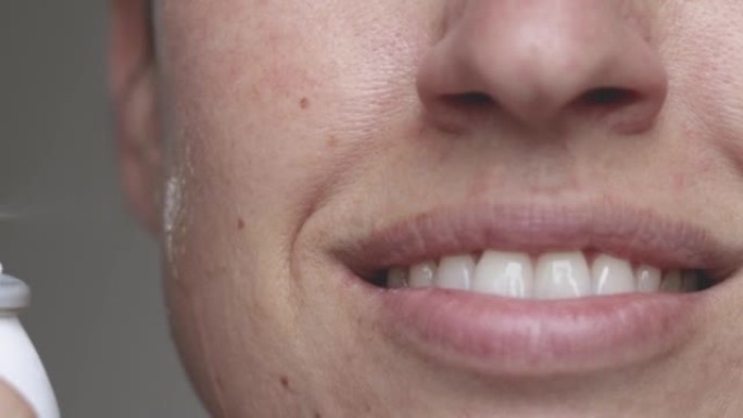微笑的女人涂在脸上的热水美容护肤
