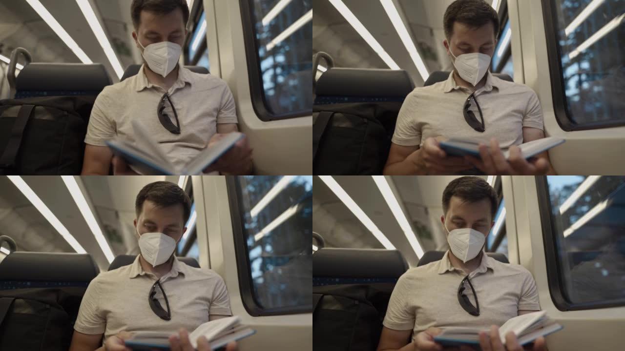 乘坐公共交通工具的乘客戴着防护口罩坐在窗户旁看书。一名男子戴着防护口罩在德国火车上旅行，看书。德国铁