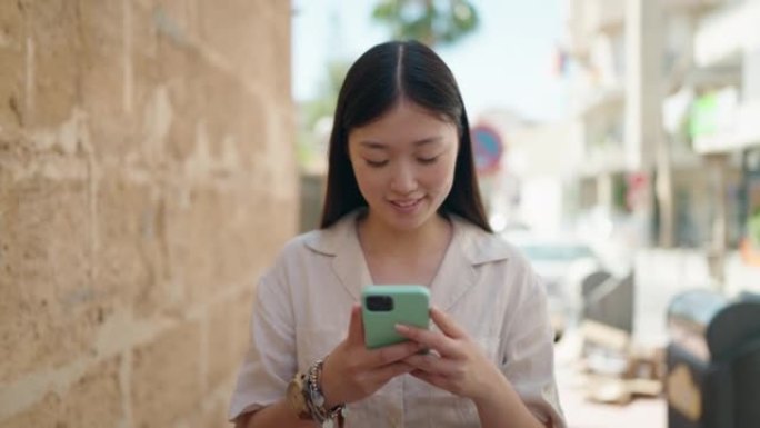Chinese woman smiling confident using smartphone a