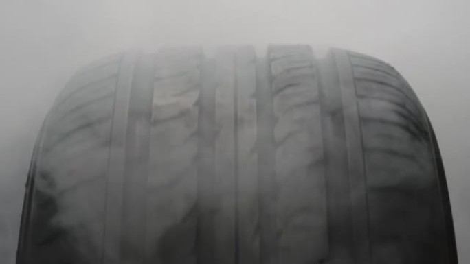 汽车车轮被灰色烟雾笼罩