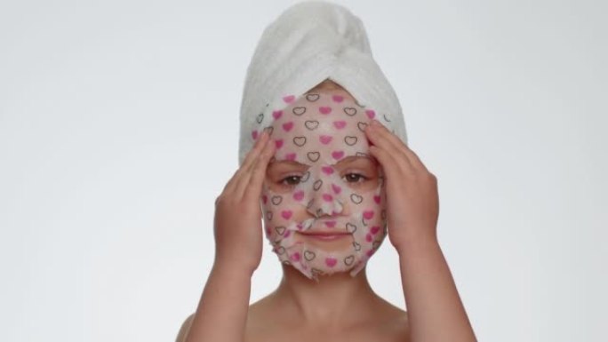 Child girl applying cosmetic moisturizing face mas