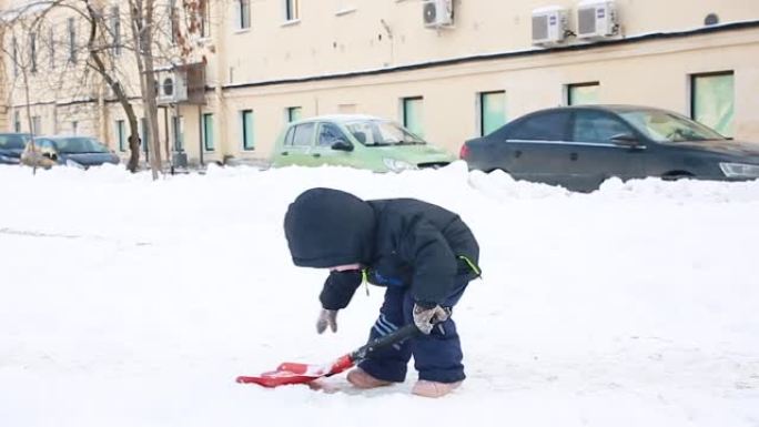 一个穿着冬装的小男孩挖雪