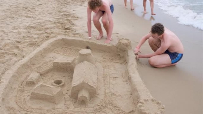 一个大男孩正在海滩上建造沙堡