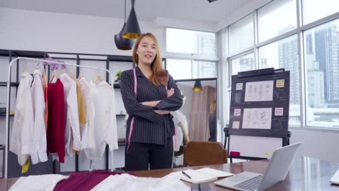 业主企业亚洲年轻女性时装设计师在陈列室为她的设计师工作。