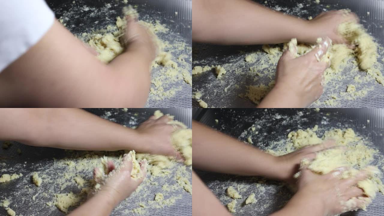 女性双手强烈揉捏由杏仁粉，马苏里拉奶酪，鸡蛋，奶油奶酪和发酵粉组成的面团