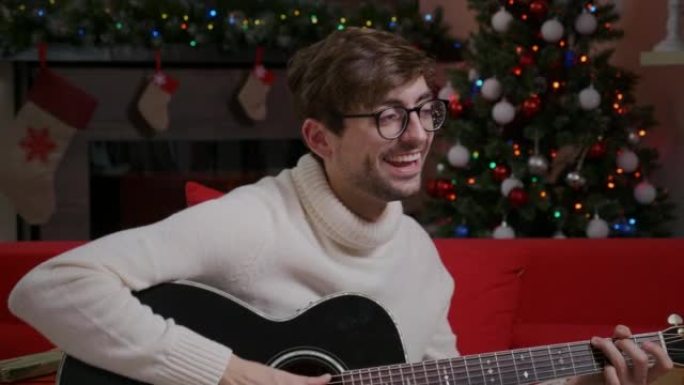 Man close up playing Christmas song on guitar near