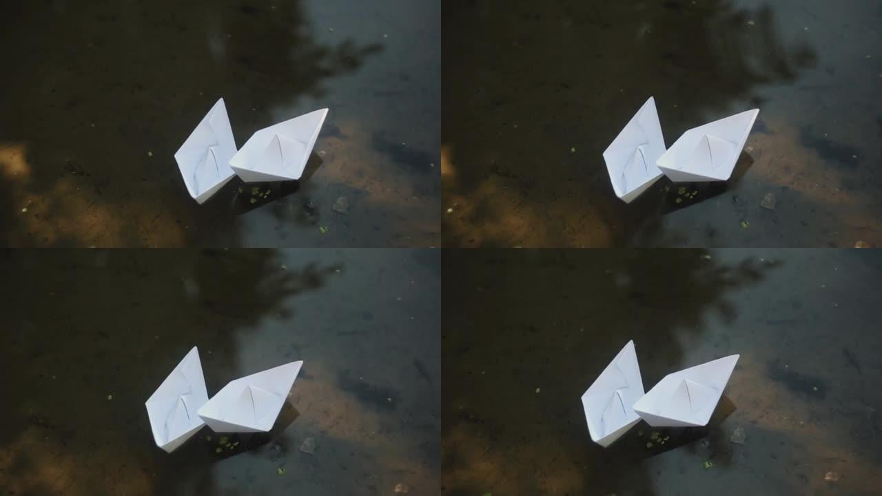 两艘纸船漂浮在水面上