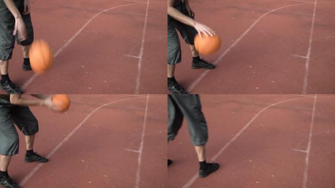 业余篮球运动员练习控球和得分技巧，运球并在公园的街头球场上投篮