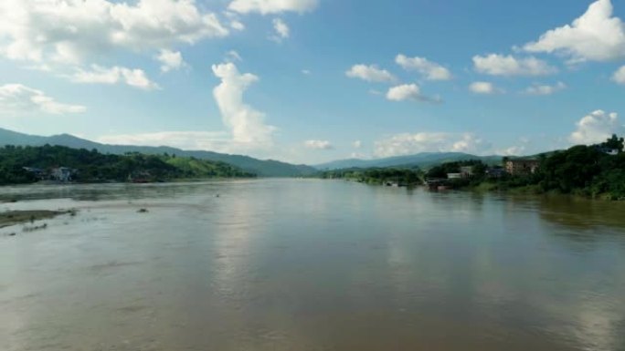 4k电影性质的航拍镜头，一架无人机在泰国和老挝之间的边界上飞越湄公河，在美丽的晴天面向群山。