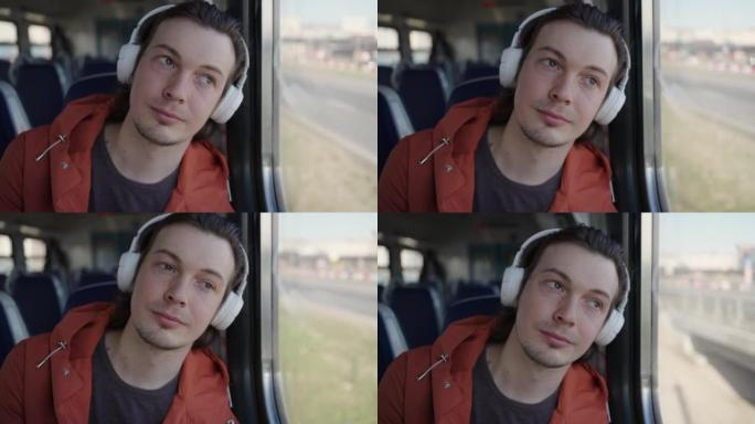 男子在乘火车旅行的耳机中听音乐