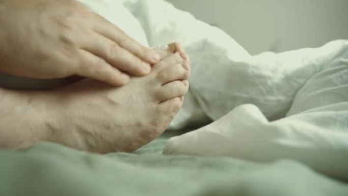 一名男子用手在脚底涂抹抗真菌药膏。