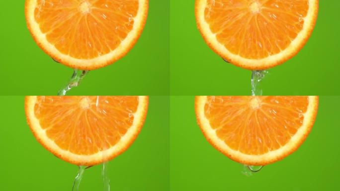 水从绿色背景上的橙色色调橙色落下。橙片和水飞溅，果汁从多汁的水果中掉落。制作水果鸡尾酒，喝冷柠檬水