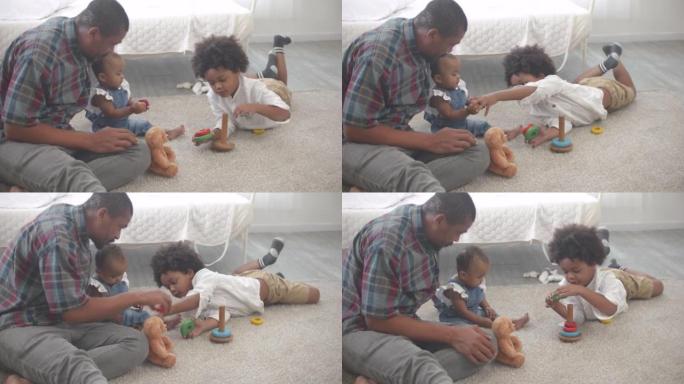快乐的非洲裔美国爸爸和两个可爱的小孩儿子和女儿在卧室里玩耍和玩耍