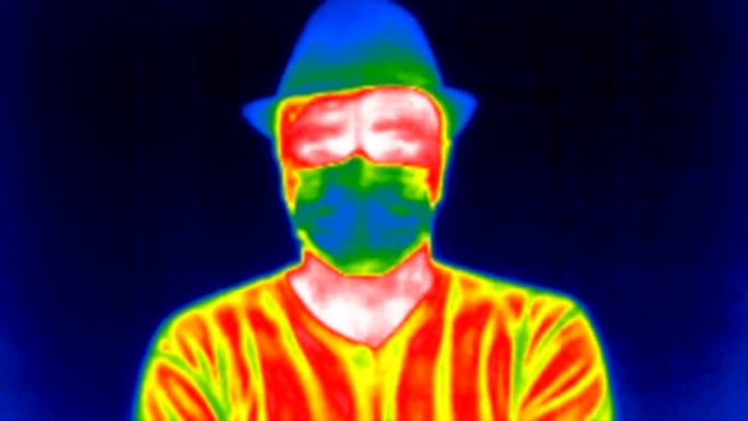 男子戴着防护医用口罩呼吸，hello向热像仪挥手，以检测体温升高