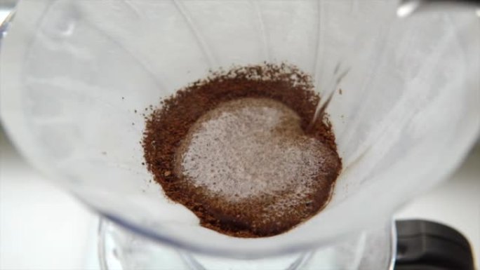 咖啡师用咖啡将水倒入过滤器，冲泡替代咖啡