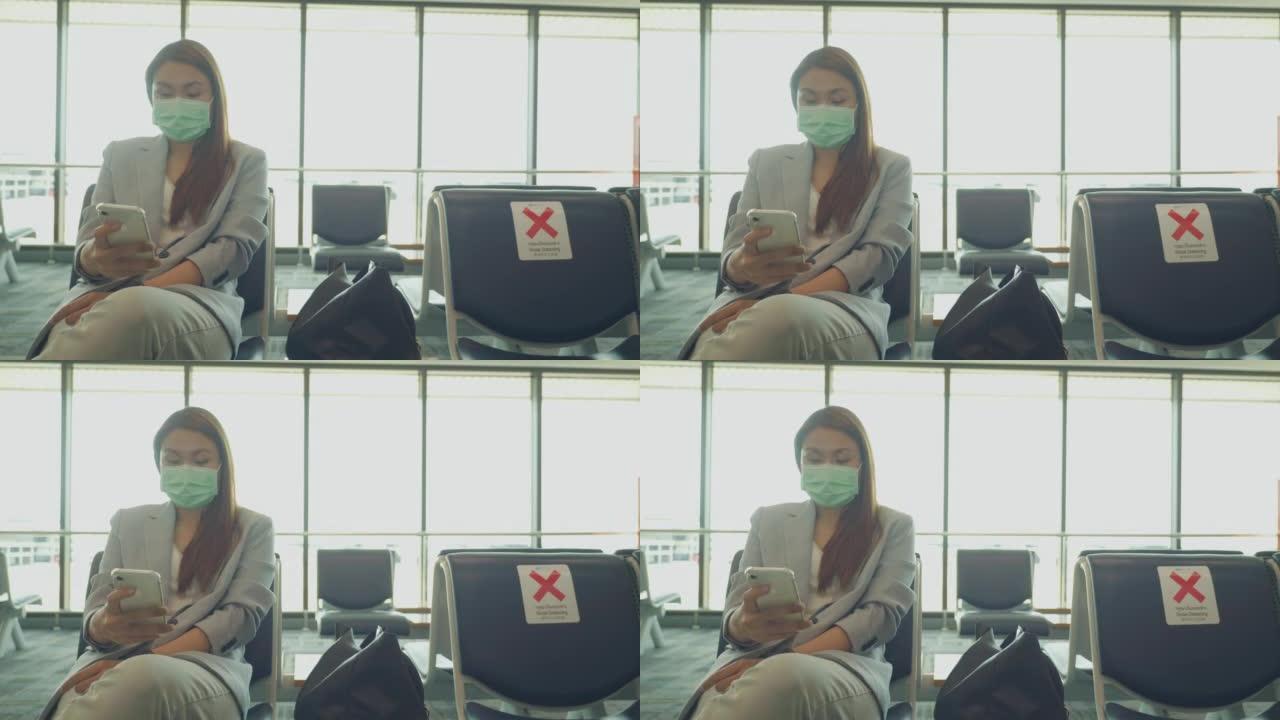 东南亚商人在国际机场等待她的航班和使用智能手机