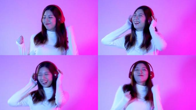 音乐世界概念，穿着白色衬衫和红色耳机的年轻亚洲女性在紫色霓虹灯背景上聆听muusic和dancinn
