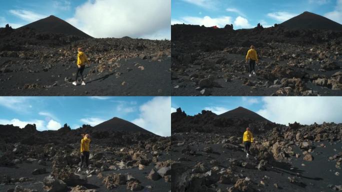 女旅行者在特内里费岛泰德国家公园的钦耶罗火山周围的熔岩田野中漫步。去任何地方。另一个星球的表面。