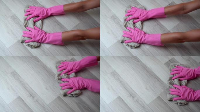 妇女戴着手套的手用抹布洗地板