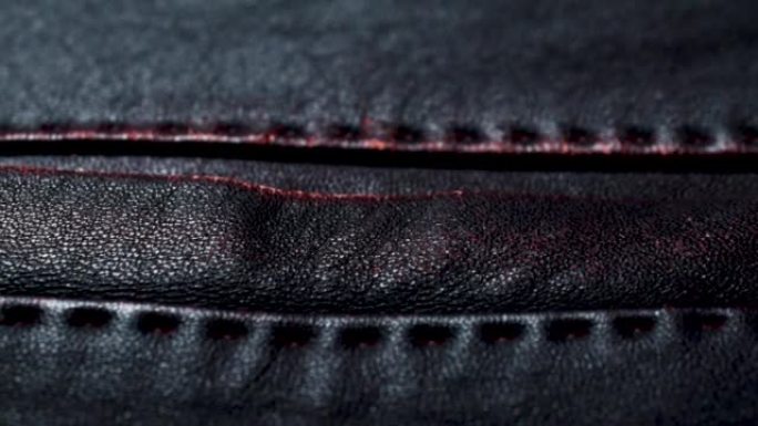 深红色棕色皮夹克上的口袋接缝。时尚背景的特写皮革纹理