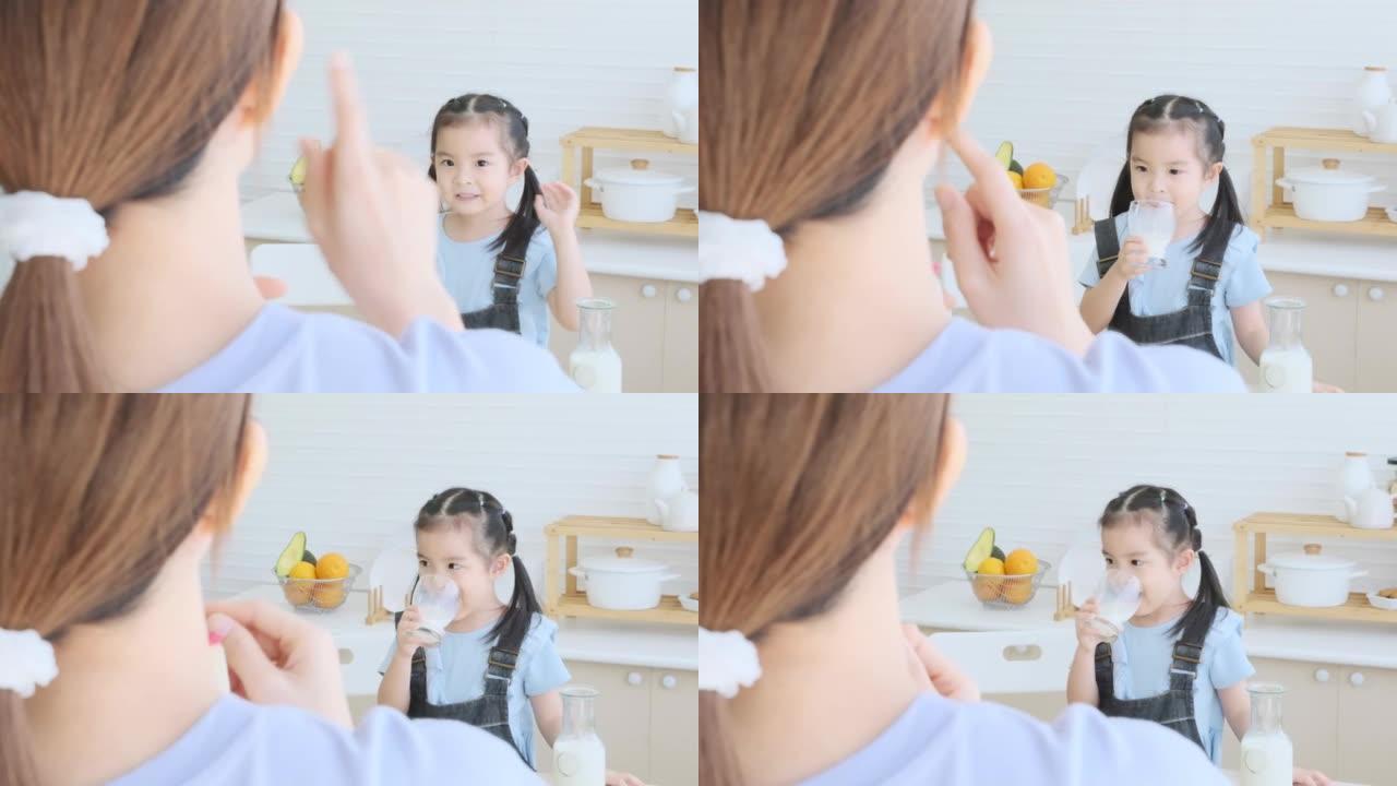 Cute daughter drinking milk with mother for take c