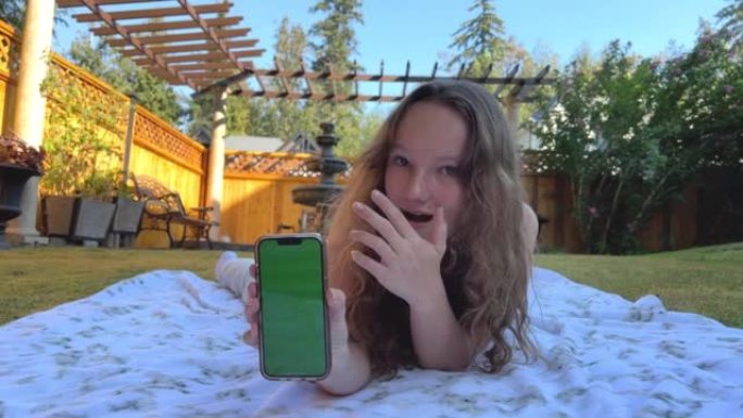 一个穿着一身运动白色衣服的少女看着画面，微笑着展示了一个绿色屏幕的手机，你可以在上面放置社交网络或其