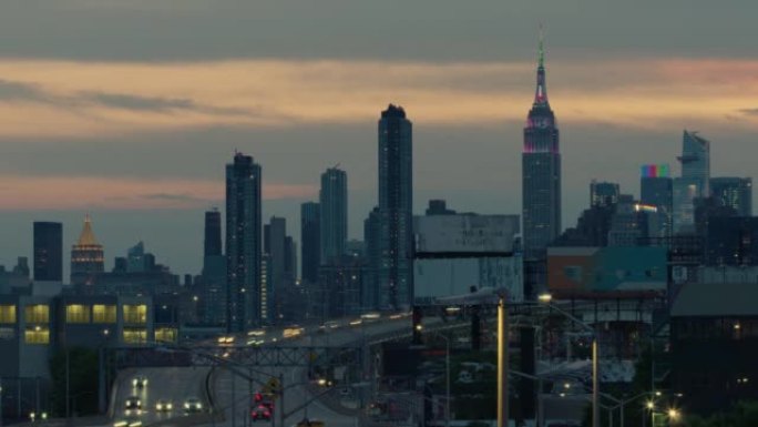 日落时纽约市天际线的延时，帝国大厦以彩虹色点亮，骄傲月
