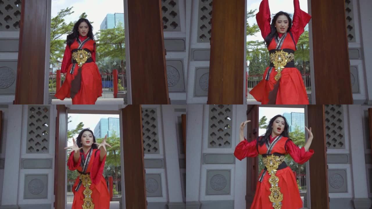 一名亚洲女子穿着中国红连衣裙时全力以赴跳舞