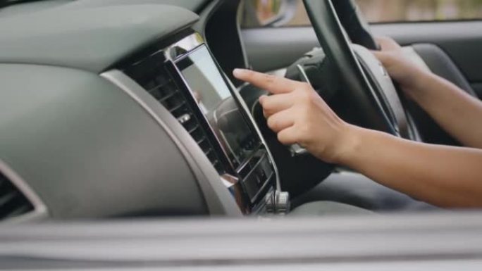 汽车智能多媒体触摸屏系统上的驾驶员手指更换广播电台。汽车仪表板上的现代触摸屏音频立体声系统。运输和车