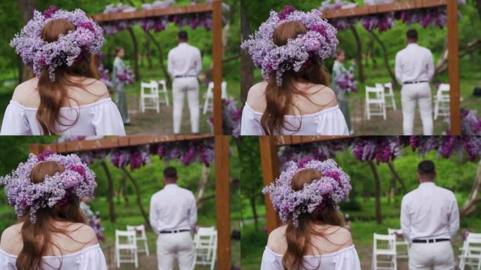 美丽的紫丁香花环新娘沿着过道走，而新郎在拱门等待