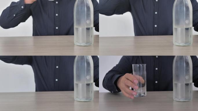 一个男人从杯子里喝水，然后放下一个空杯子