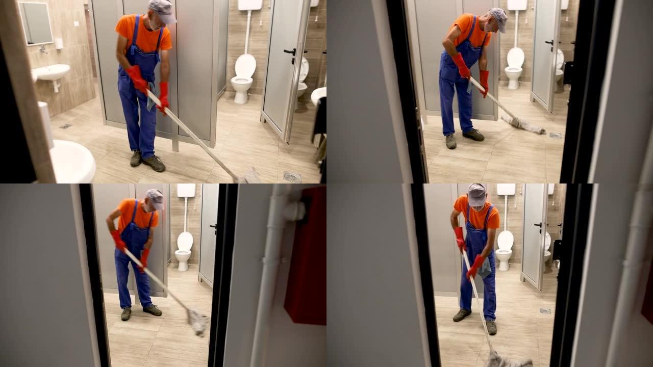 Cleaning man mopping the floor in restroom