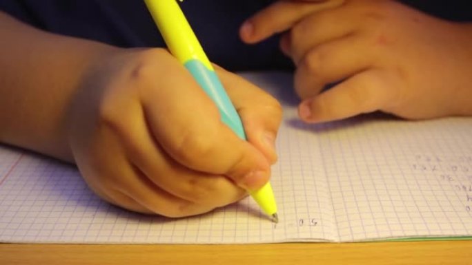 学生在笔记本上解决数学示例的手的特写。