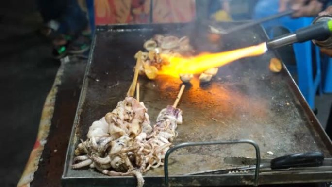 切片和沙爹鱿鱼在夜市烧烤，印度尼西亚受欢迎的街头小吃。选择性聚焦