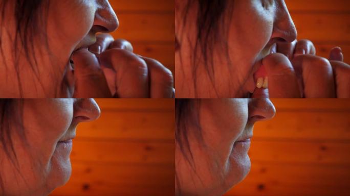 老年女性从嘴里取出假牙。义齿的插入。牙科概念。使用假牙的女人。养老金领取者从嘴里取出人造牙齿。口腔和