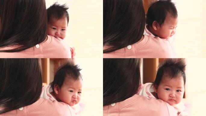亚洲新生婴儿被妈妈抱在肩上，母亲的生活方式在家照顾婴儿，好奇的小女孩与无辜的孩子环顾四周，快乐的女人