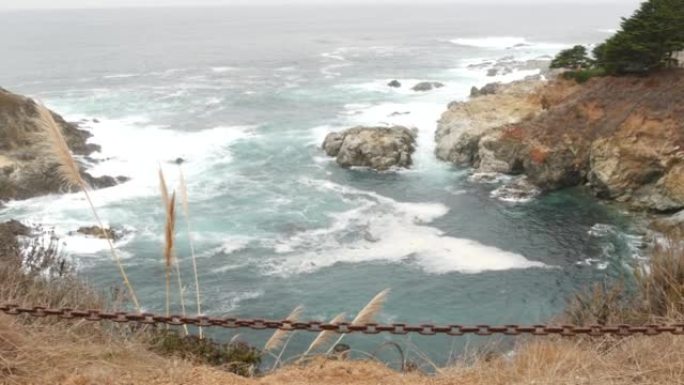 岩石崎岖的海洋，有雾的天气。海浪冲击海滩。加利福尼亚，大苏尔。