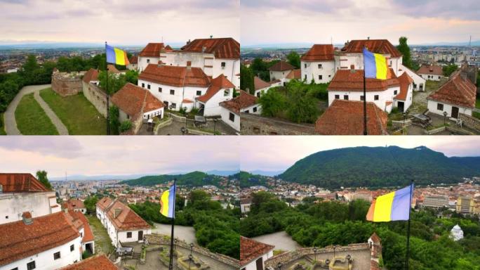 罗马尼亚布拉索夫城堡的空中无人机视图。中世纪的堡垒和国旗在山顶上。周围的建筑物和绿树