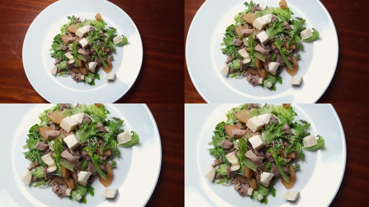木制桌子上的菜上加煮鸭肉沙拉