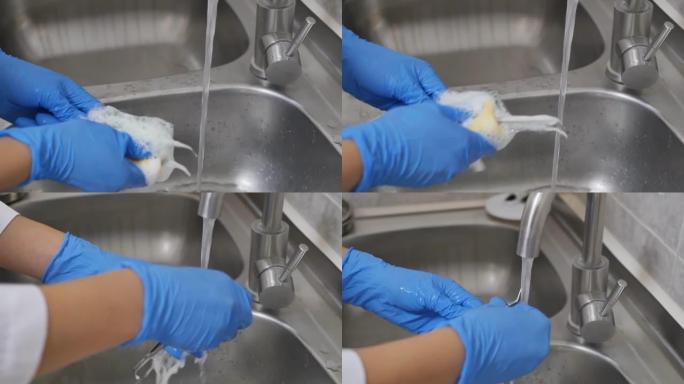 使用肥皂海绵和水槽水龙头中的自来水对牙科器械进行消毒的过程。戴着蓝色手套的牙科助理的手洗牙医的工作工