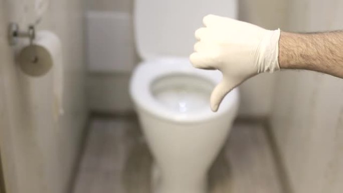 男子在厕所的背景上露出拇指，戴着白色乳胶手套