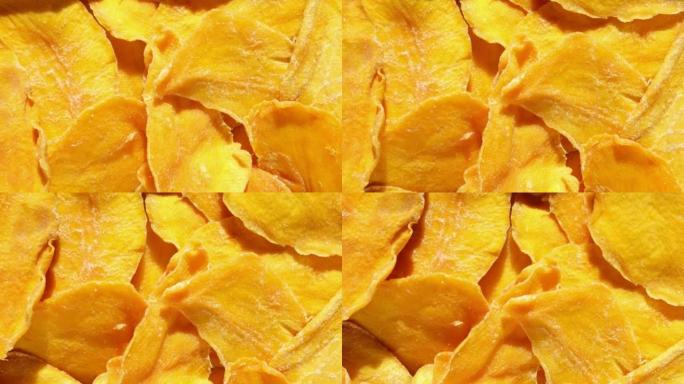 芒果干切片特写在白色上。顶视图。特写。芒果薯片背景。脱水脆皮水果片、片。一堆晒干的黄色水果。健康餐。